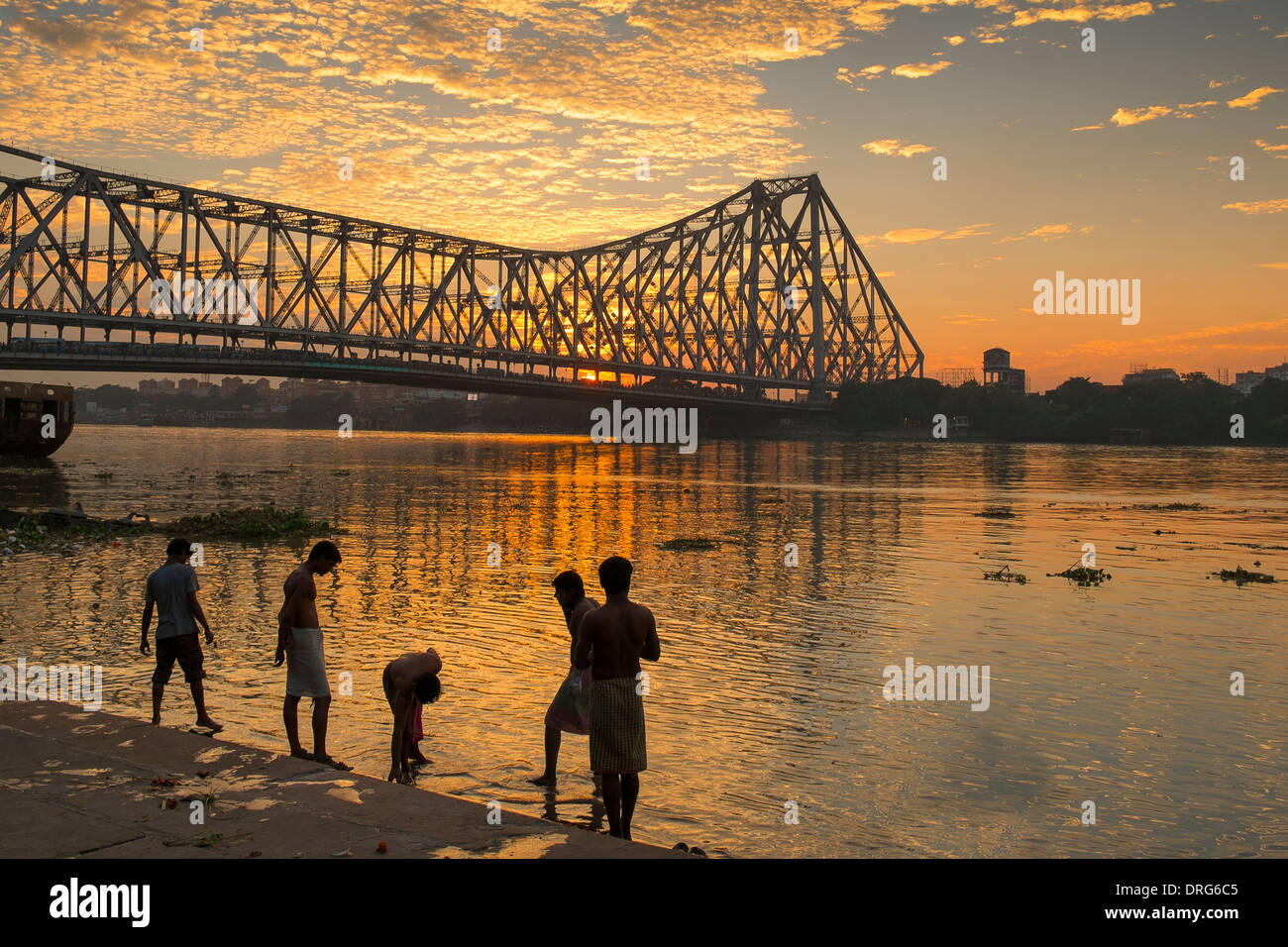 Indien, Westbengalen, Kolkata (Kalkutta) Männer waschen in der Nähe von Howrah Brücke bei Sonnenuntergang Stockfoto