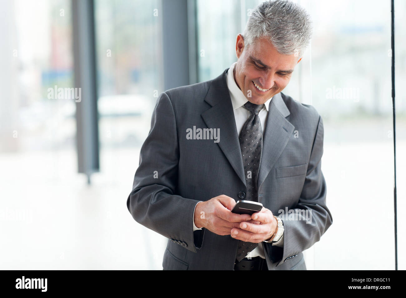 fröhlich Mitte Alter Geschäftsmann mit Smartphone Stockfoto
