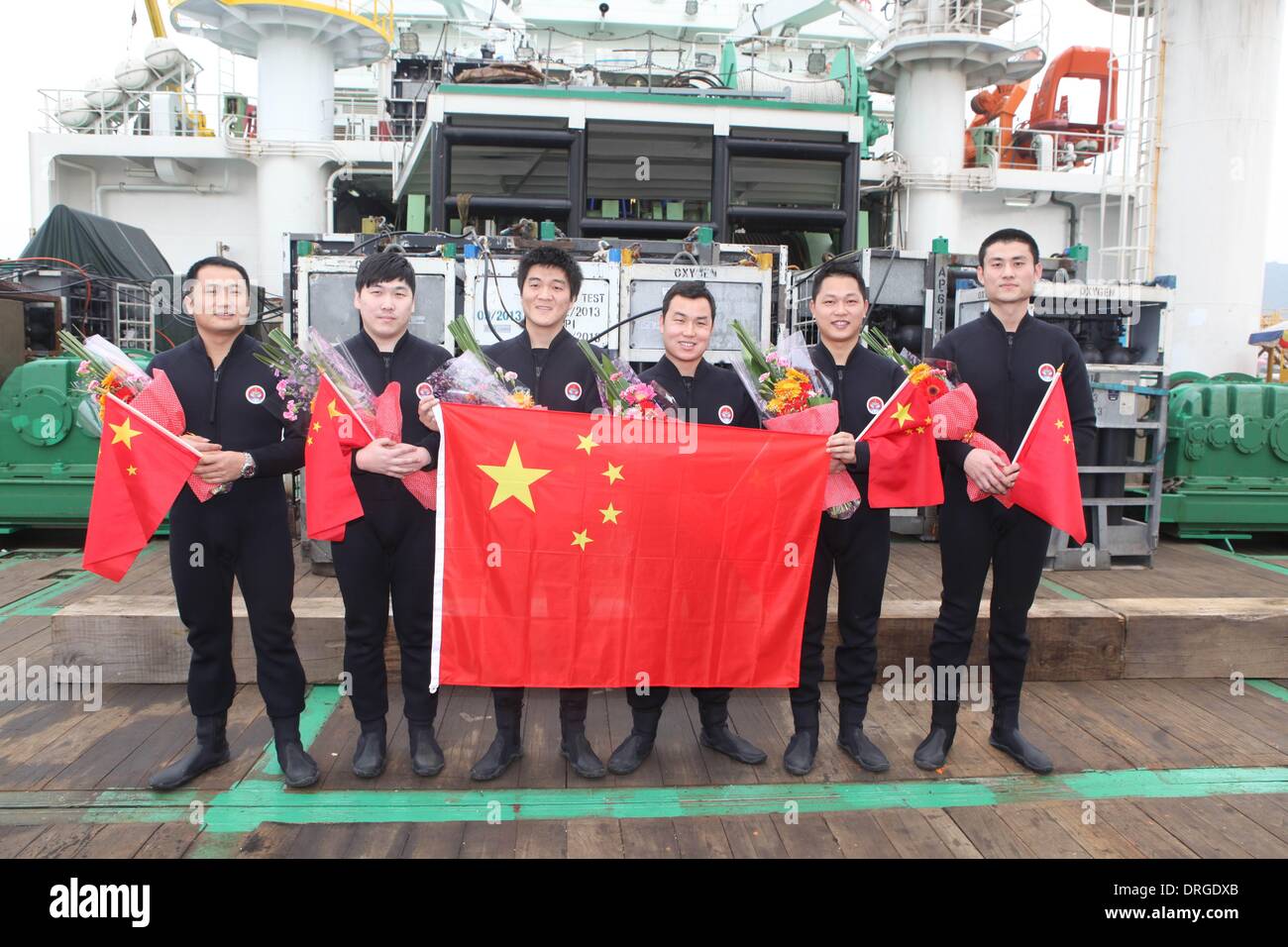 (140125)--SHENZHEN, 25. Januar 2014 (Xinhua)--Sic Taucher Pose für ein Gruppenfoto nach dem coming out sicher von einer lebendigen Kammer auf einem Schiff an einem Dock in Shenzhen, Guangdong Provinz Süd-China, 25. Januar 2014 verankert. Eine Taucherglocke nahm die Taucher zu erreichen eine Tiefe von 313,5 m unter dem Südchinesischen Meer am 12. Januar. Dann kehrte die Taucher aus tiefem Wasser in der lebenden Kammer auf ihr Schiff. Nach einem Aufenthalt in der Kammer für 380 Stunden das Inertgas in ihrer Gewebeflüssigkeit auf Normaldruck zurückkehren zu lassen, kam die sechs Taucher auf Jan. 25 mit gesunden Körper Bedingungen. Diese setzen eine erfolgreiche con Stockfoto
