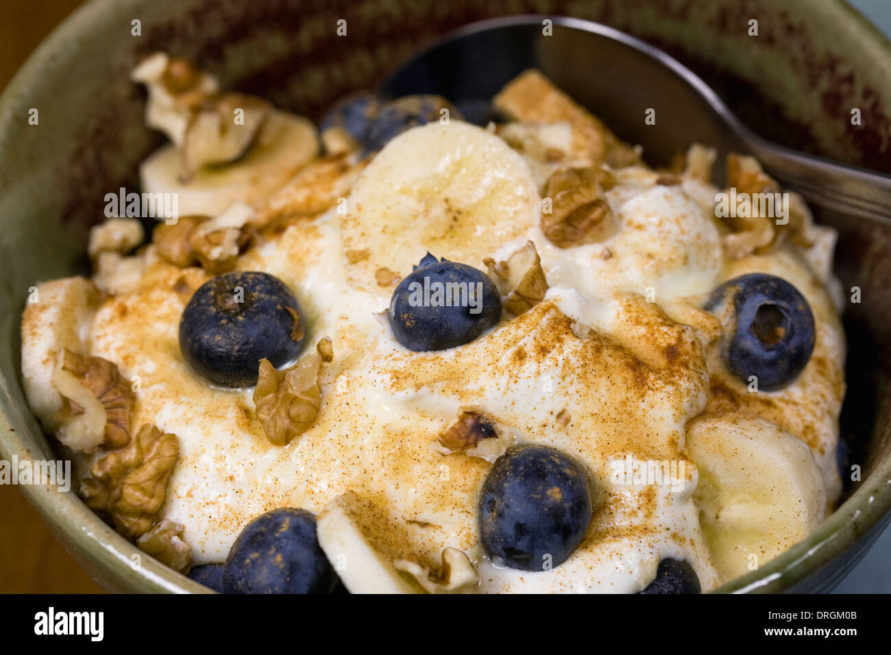 Ein gesundes Frühstück. Joghurt mit Banane, Heidelbeeren, Walnüssen und einer Prise Zimt. Stockfoto