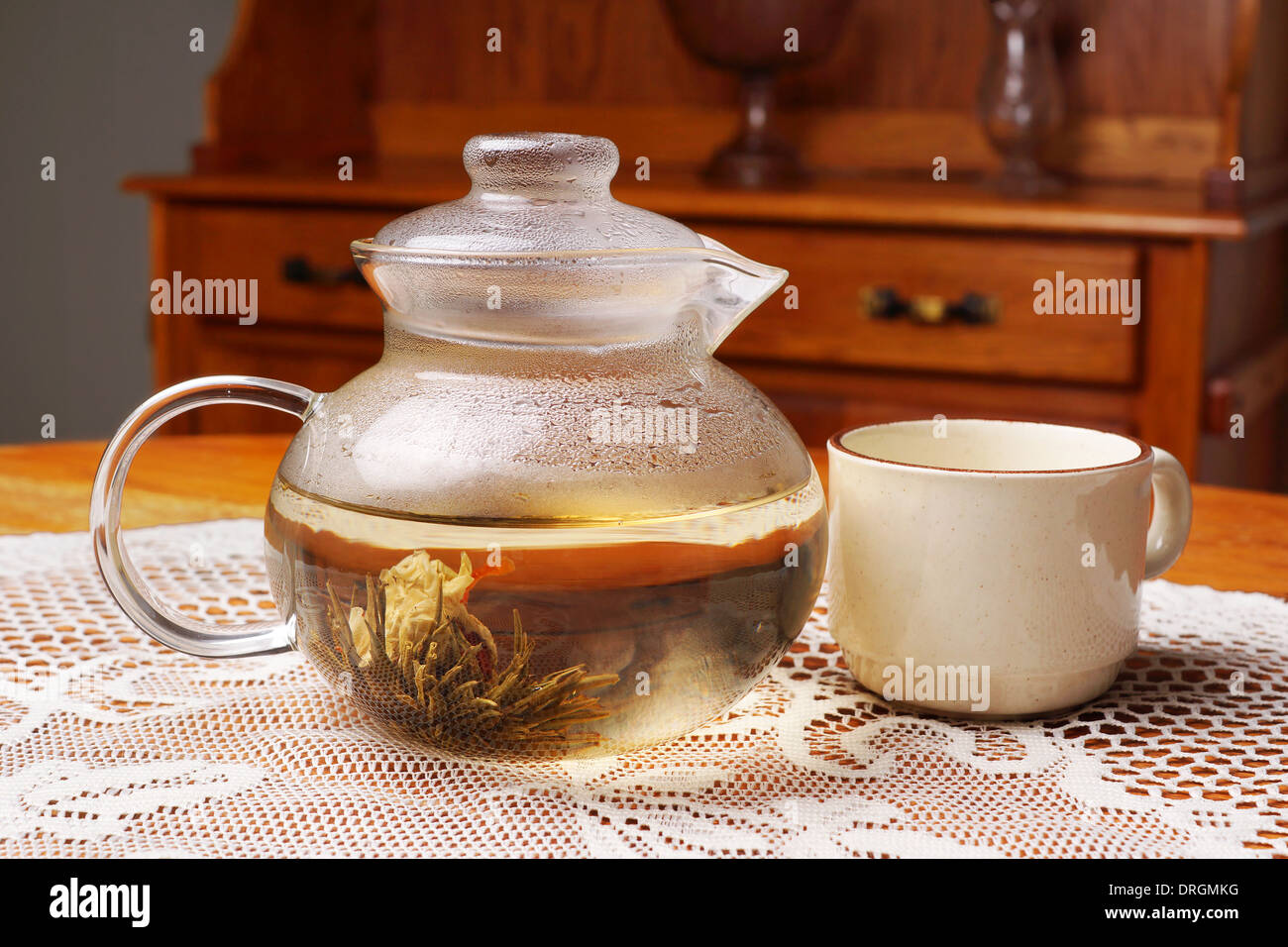 Blüten-Tee im Glas Teekanne mit Tasse, Vintage-look Stockfoto