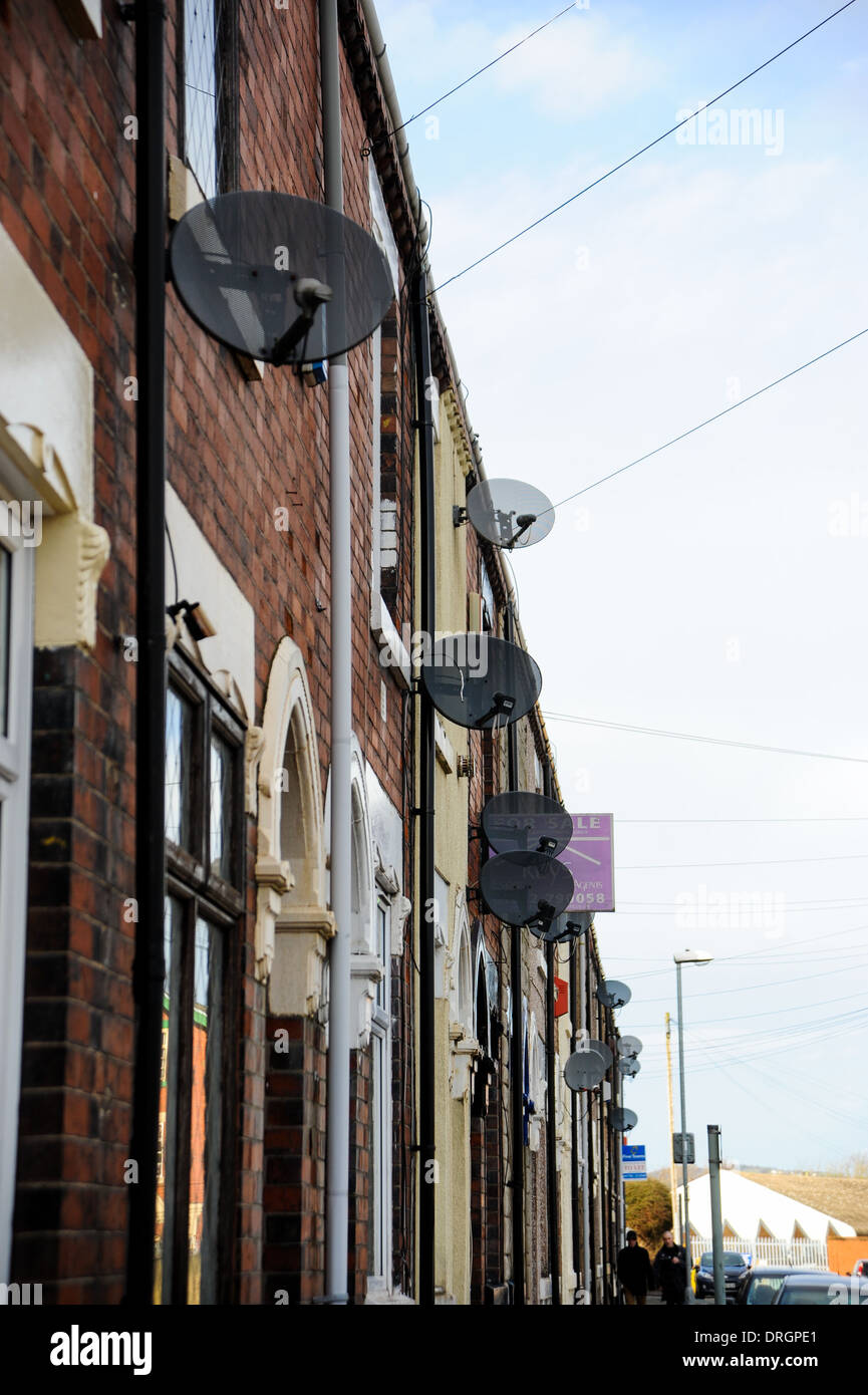 TV Sender Satellitenschüsseln auf Seiten der Häuser auf terrassenförmig angelegten Straße in Burslem Stoke-on-Trent Staffordshire Stockfoto