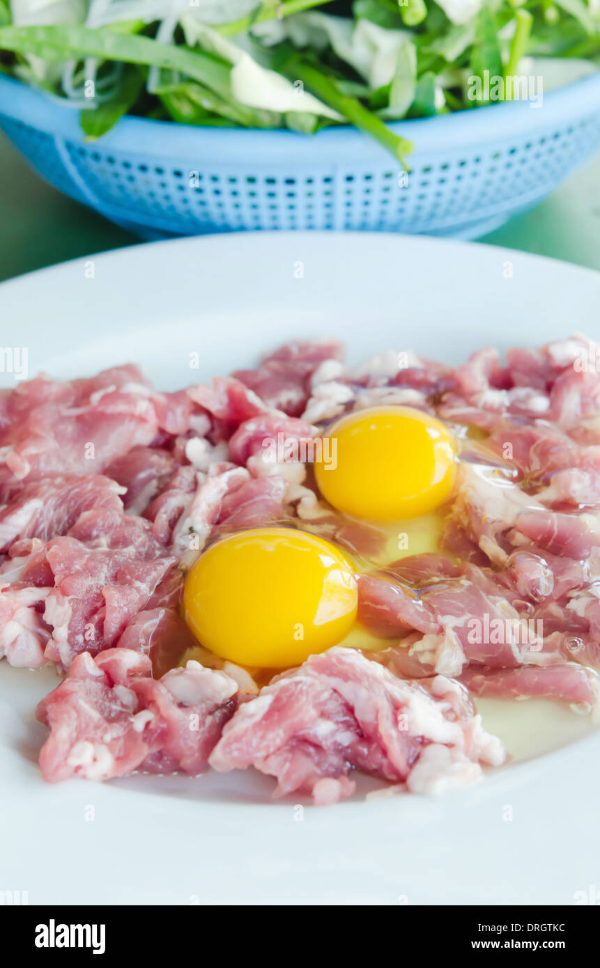 rohes Fleisch und frisch geschnittenem Schweinefleisch, Ei Eigelb bereiten Sie für das Kochen. Stockfoto