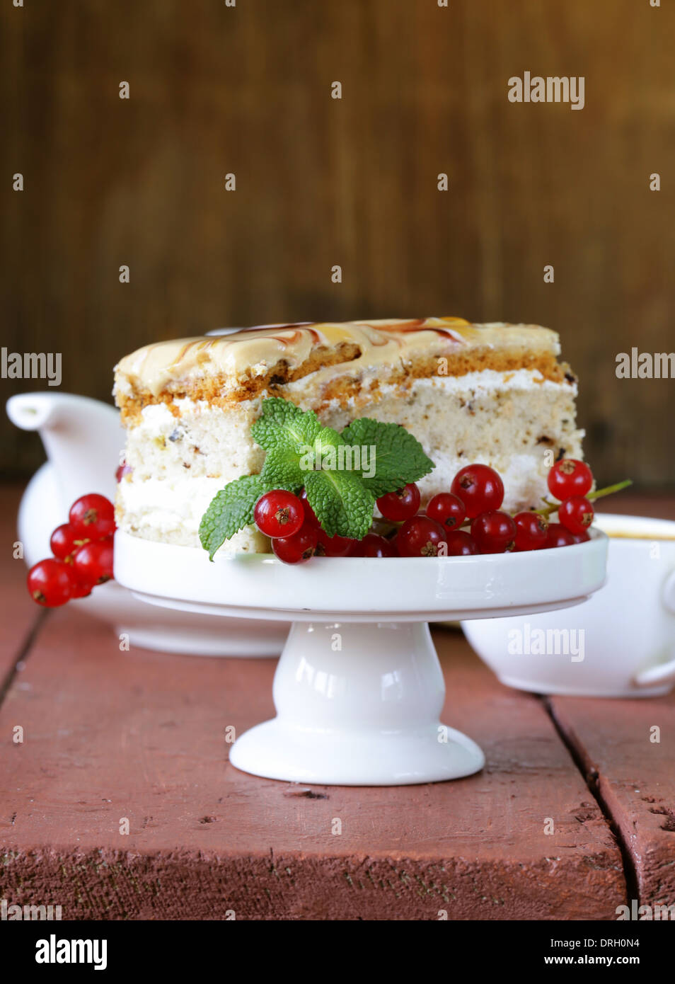 Stück Vanille Kuchen verziert, Karamellsauce und Johannisbeere Stockfoto