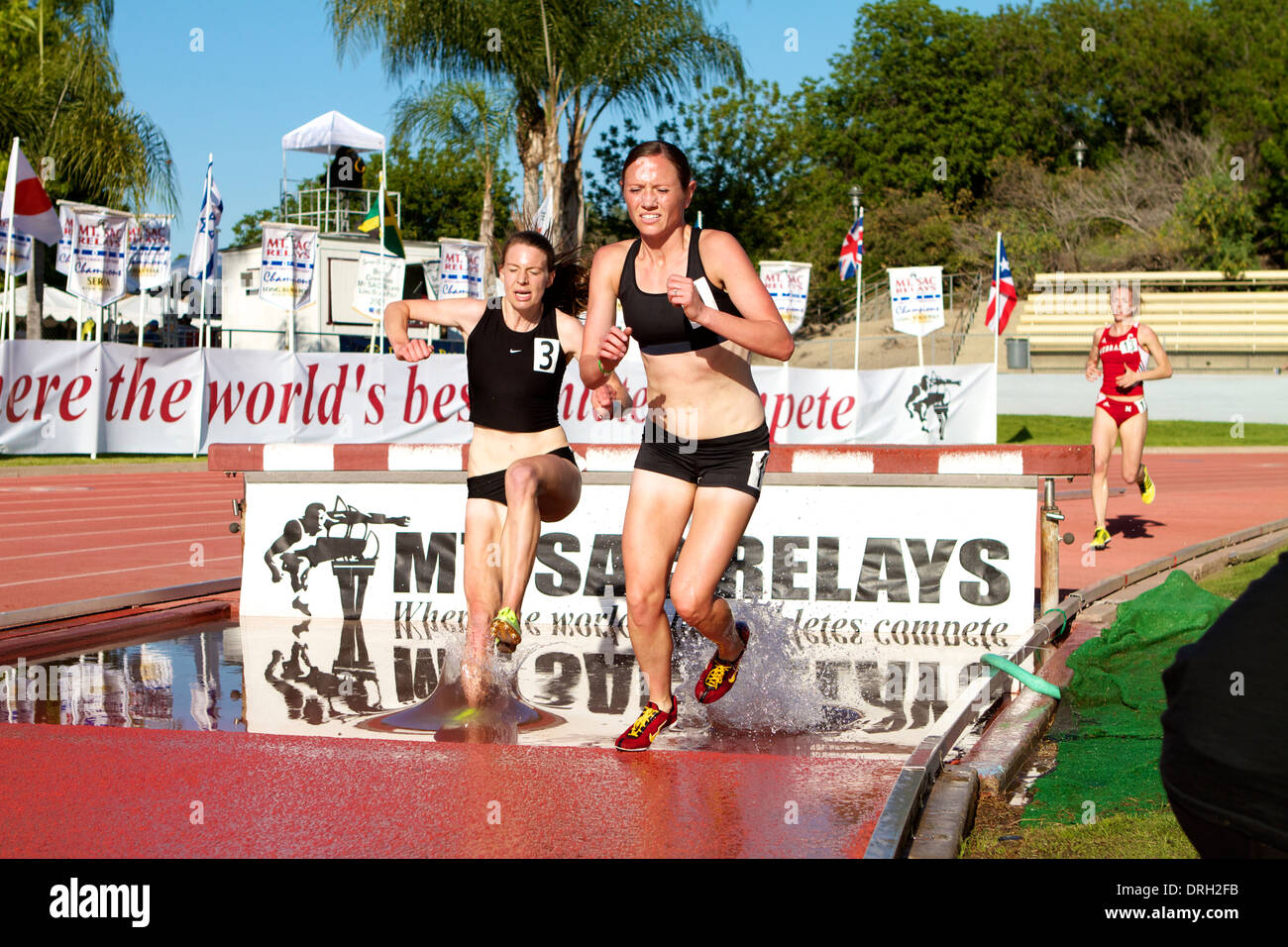 Weibliche Athleten in den Wassergraben beim Hindernislauf bei einem amerikanischen Leichtathletik Treffen in Kalifornien Stockfoto