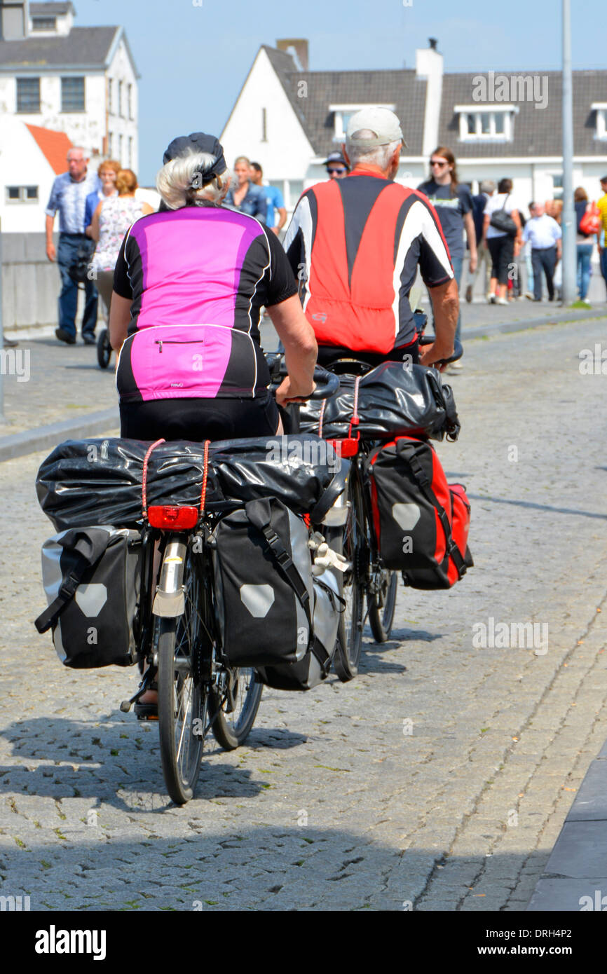 Maastricht City zurück Ansicht Paar Radfahren am sonnigen Sommertag Saint Servatius Brücke über den Fluss Maas zwei Fahrräder schwer beladen Limburg Niederlande EU Stockfoto