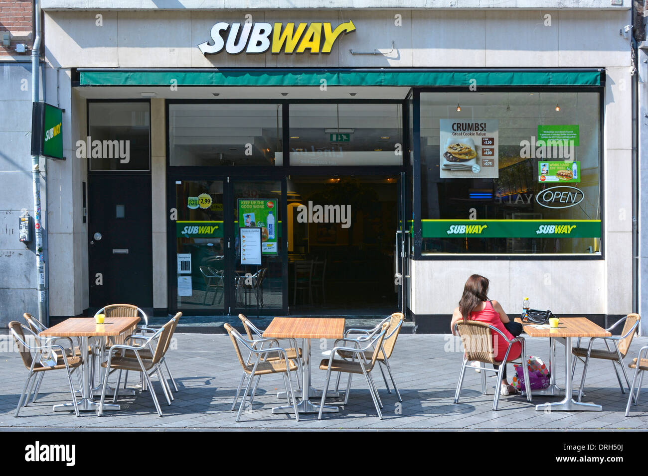Maastricht City Rückansicht Frau sitzt am Pflastertisch vor einem Subway Sandwich Shop Geschäft sonniger Juli Sommertag in Limburg Niederlande Europa Stockfoto