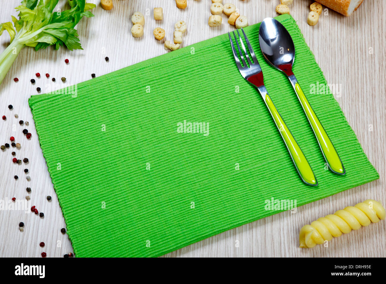eine grüne Serviette mit Besteck auf dem Tisch Stockfoto