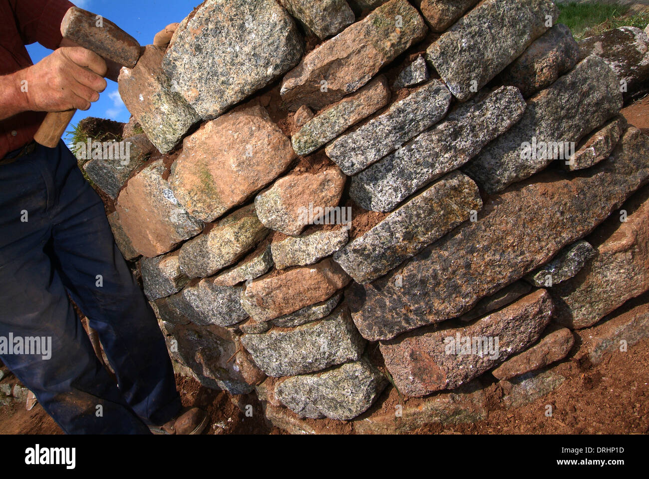 Trockenmauer-Generator, David Hannaforth mit nichts als Granitstein, den er von großen Felsbrocken teilt. Stockfoto