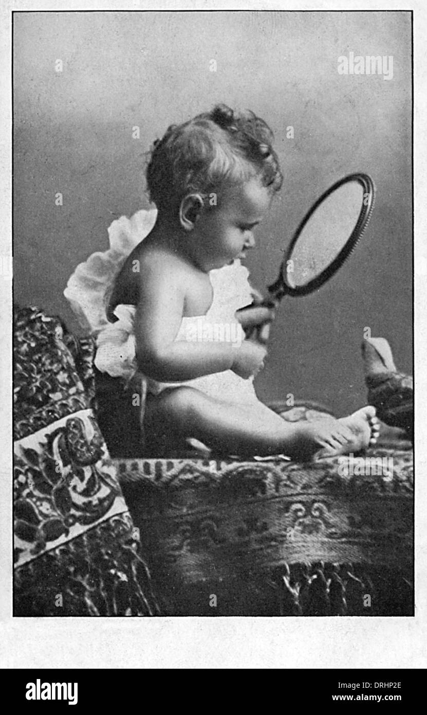 Baby Junge erstaunt über sein eigenes Spiegelbild Stockfoto