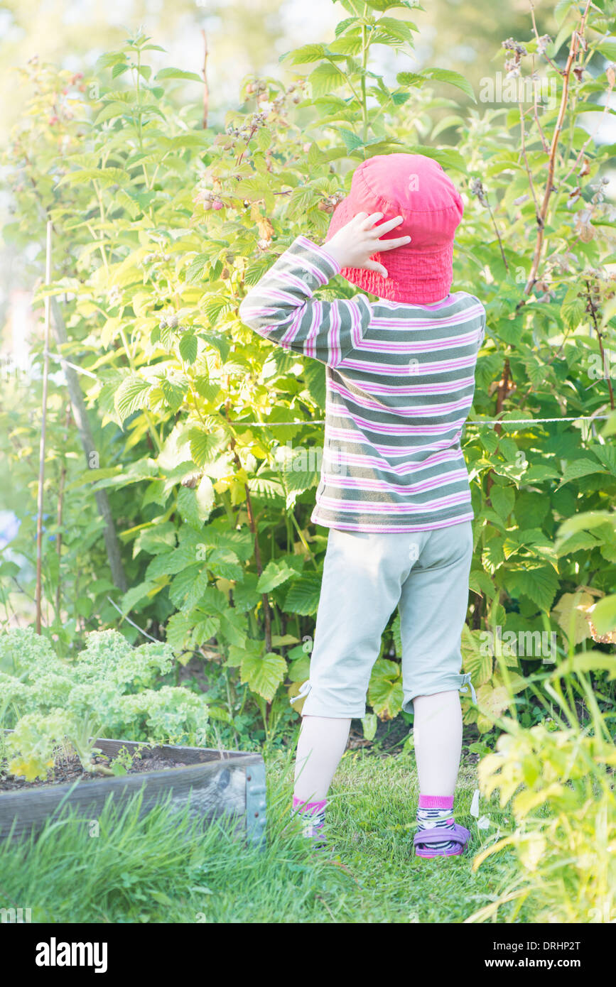 Ruhigen Sommer-Szene. Junges Mädchen im Garten, Pflanzen und Blumen zu beobachten. Stockfoto