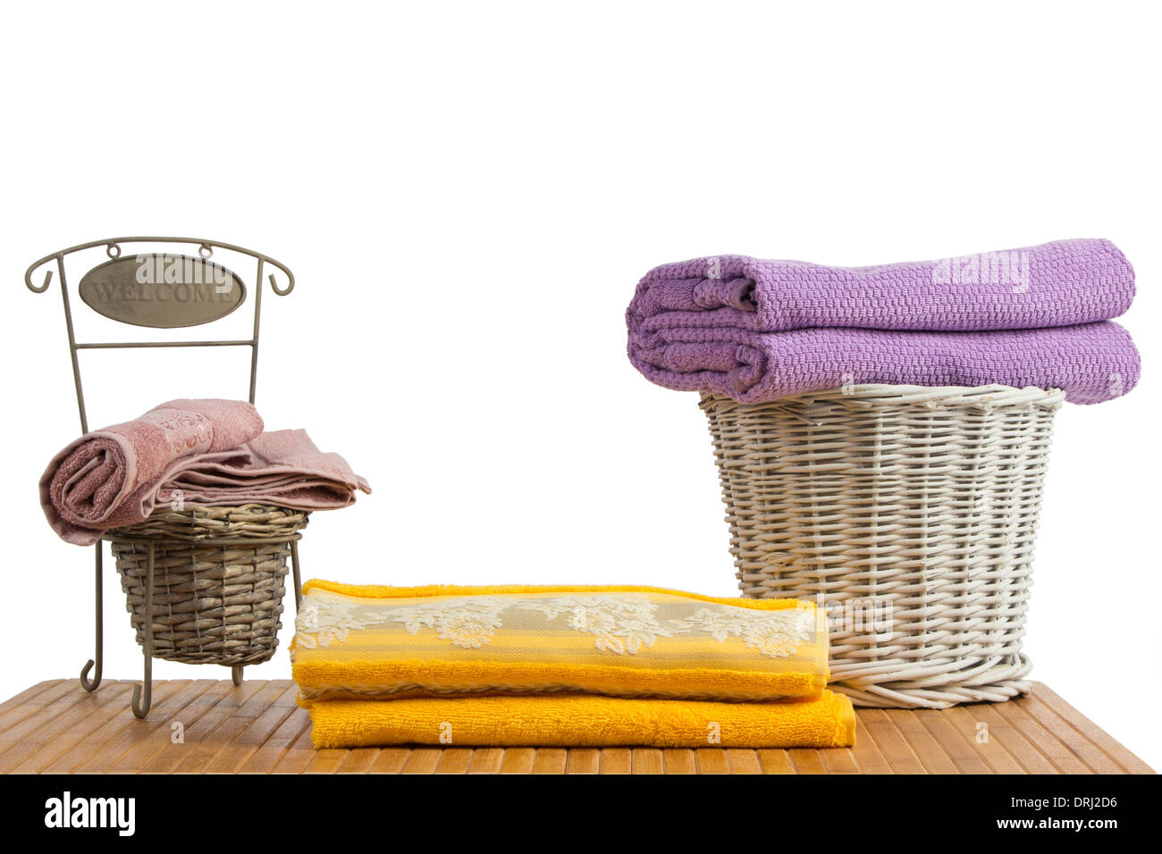 Weidenkörbe voll von farbigen Handtücher auf einem Holztisch, auf weißem Hintergrund Stockfoto