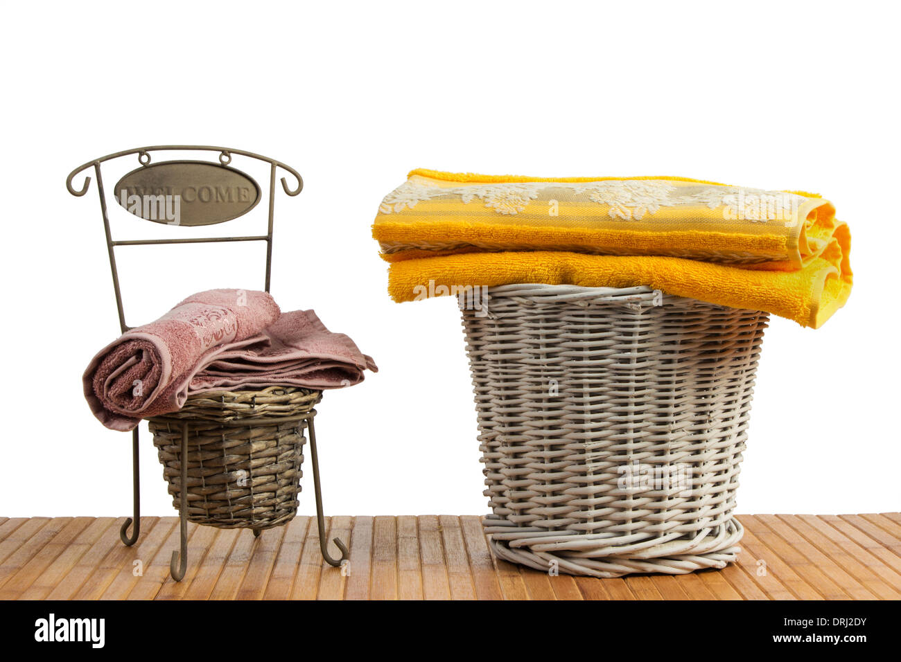 Weidenkörbe voll von farbigen Handtücher auf einem Holztisch, auf weißem Hintergrund Stockfoto