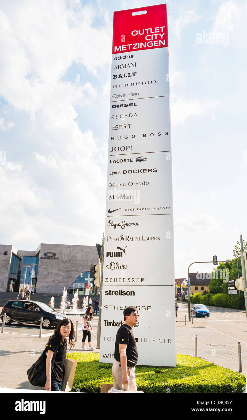 asiatische Käufer eine Hinweistafel zeigt die Marken der Hersteller in der  Metzingen Outlet City Metzingen Stockfotografie - Alamy