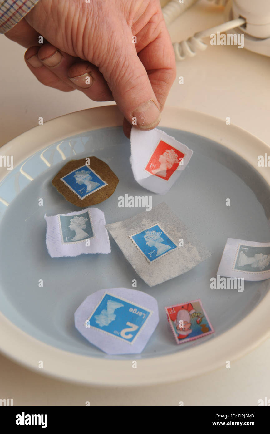 Königliche Post Briefmarken einweichen für Wiederverwendung, Geld zu sparen. Stockfoto