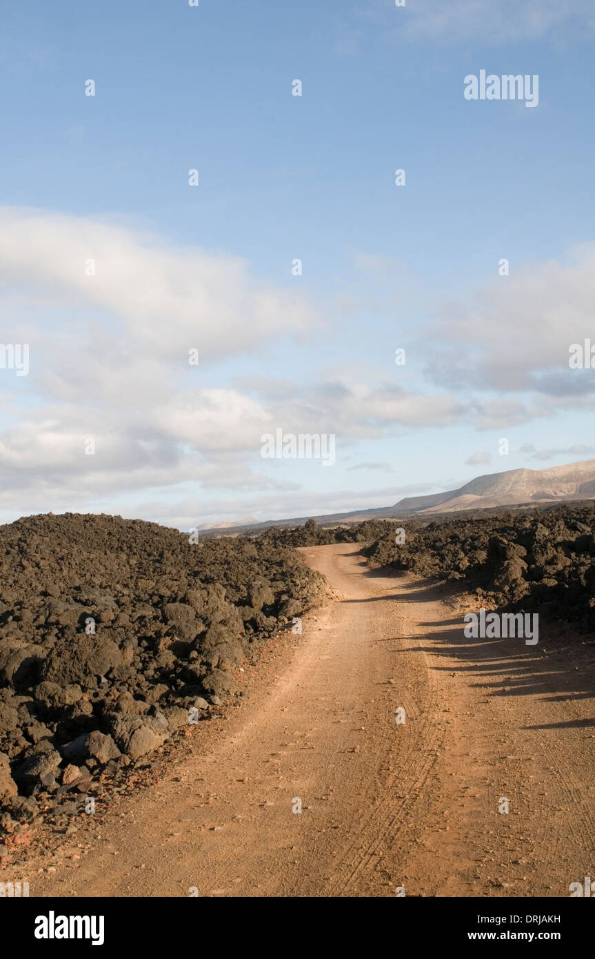 felsigen Boden unbefestigte Straße Straßen Spur verfolgt unbefestigten groben Staub durch Boulder Bereich Lava Flow Lanzarote Kanarische Inseln Stockfoto
