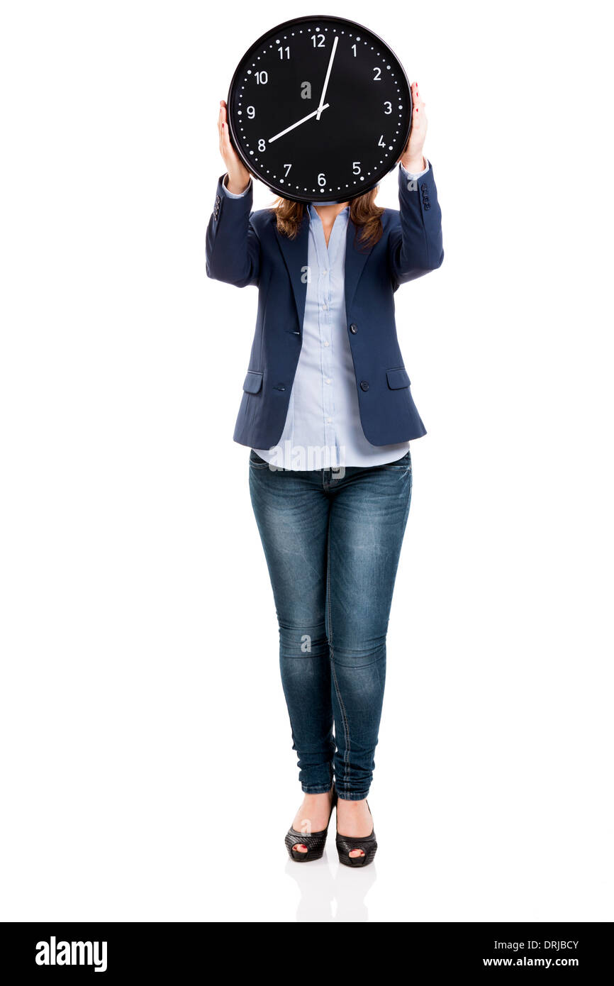 Geschäftsfrau hält eine große Uhr über den Kopf und isoliert auf weißem Hintergrund Stockfoto