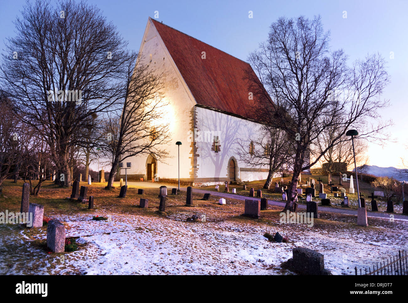 Winter-Dämmerung bricht an der historischen mittelalterlichen Trondenes Kirke Kirche, in der Nähe von Harstad, Norwegen Stockfoto