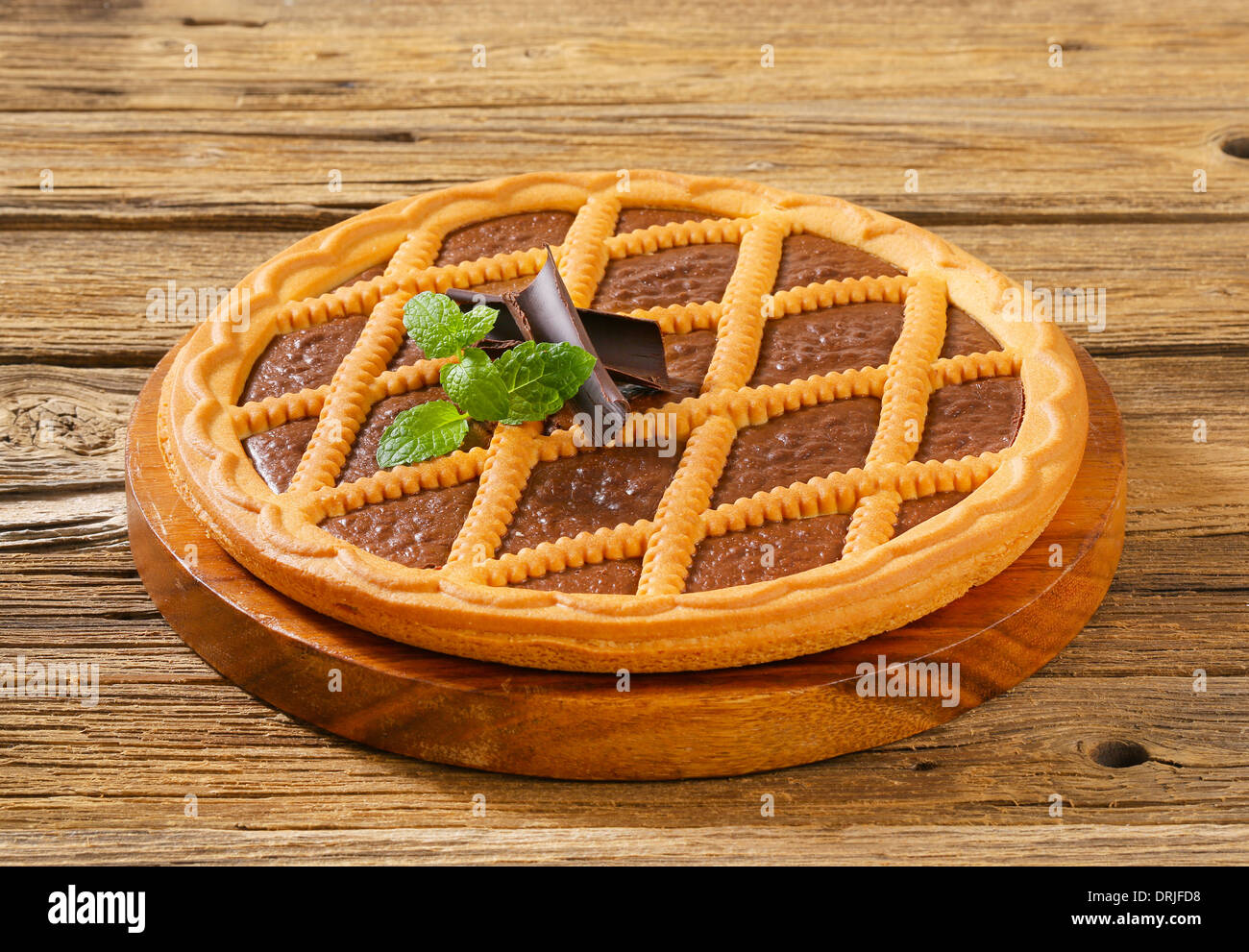 Gitter gekrönt Schokolade Torte auf Holzbrett Stockfoto