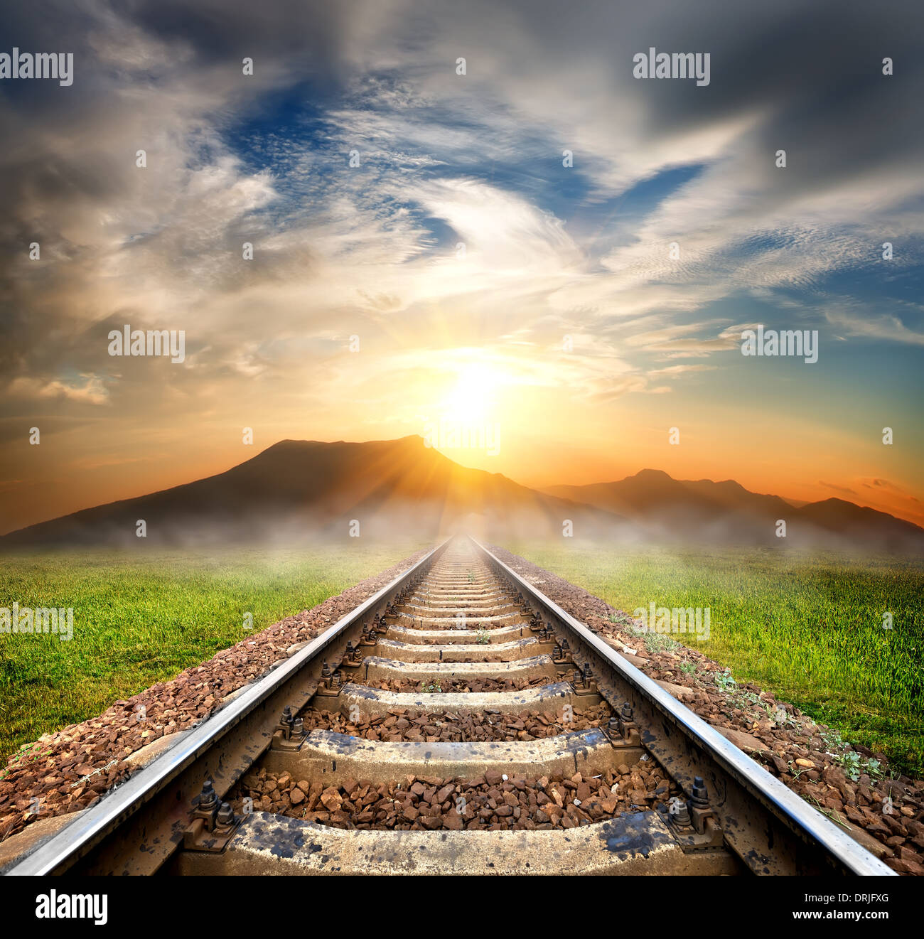Eisenbahn bis zu den Bergen im wunderschönen Sonnenaufgang Stockfoto