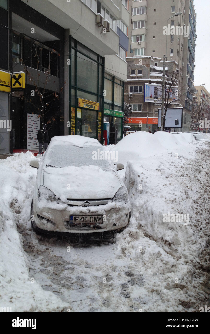 Bukarest, Rumänien. 27. Januar 2014. Autos sind bedeckt mit Schnee am Straßenrand in Bukarest, Rumänien, 27. Januar 2014 zu sehen. Rumänische Regierung erklärt Montag eine Warnung für den südlichen und südöstlichen Landkreisen Buzau, ermöglichen Braila und Vrancea besser als Reaktion auf die aktuellen Schneesturm, ab 12:00 am Montag. Bildnachweis: Lin Huifen/Xinhua/Alamy Live-Nachrichten Stockfoto