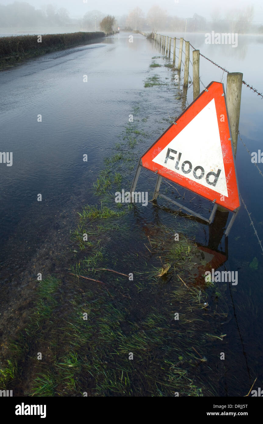 Überfluteten Landstraße mit Warnschild Stockfoto