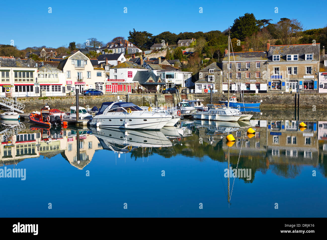 Klarer blauer Himmel reflektiert im ruhigen Wasser im Hafen von Padstow Stockfoto