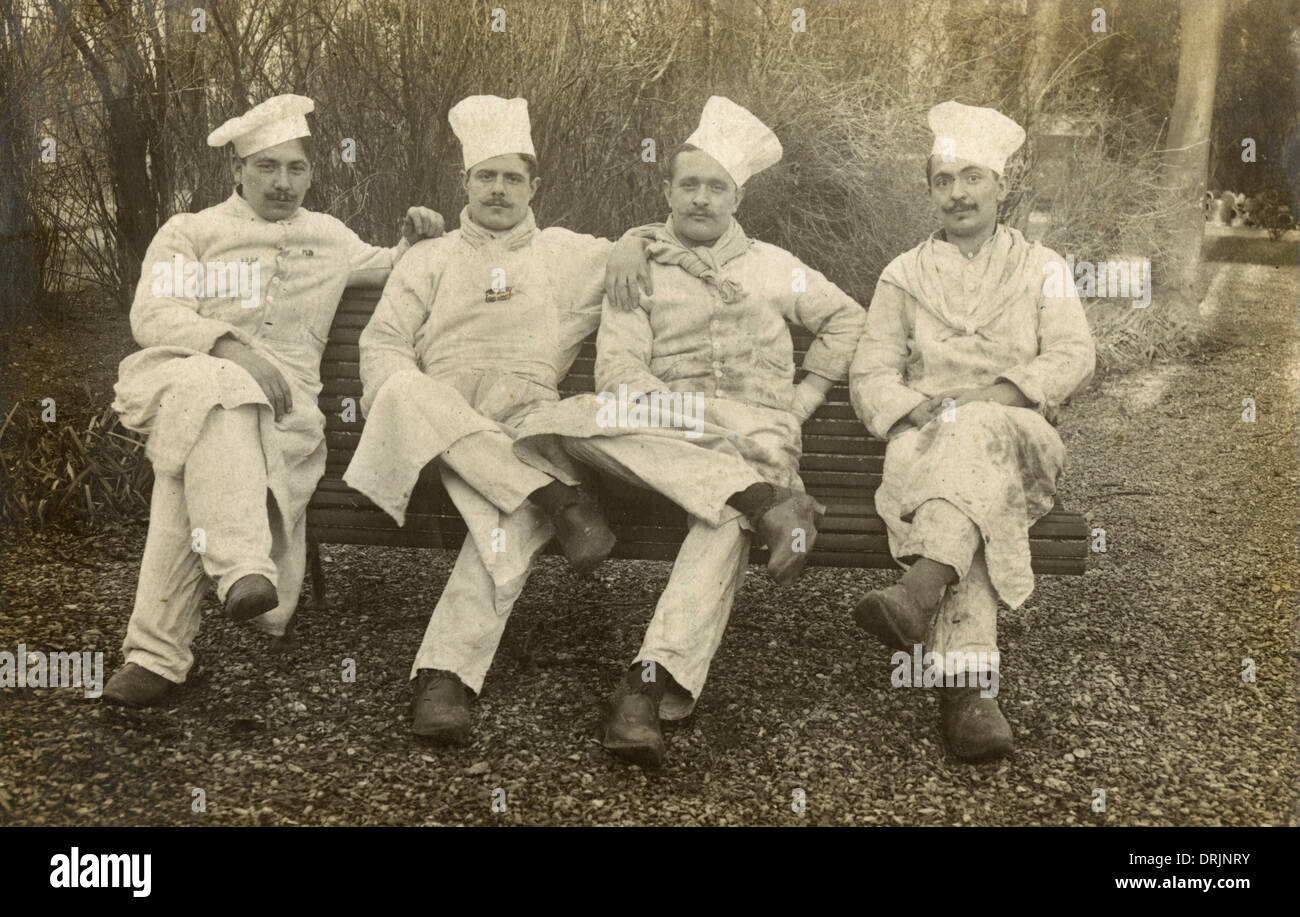 Vier französische Chefs sitzen auf einer Bank. Stockfoto