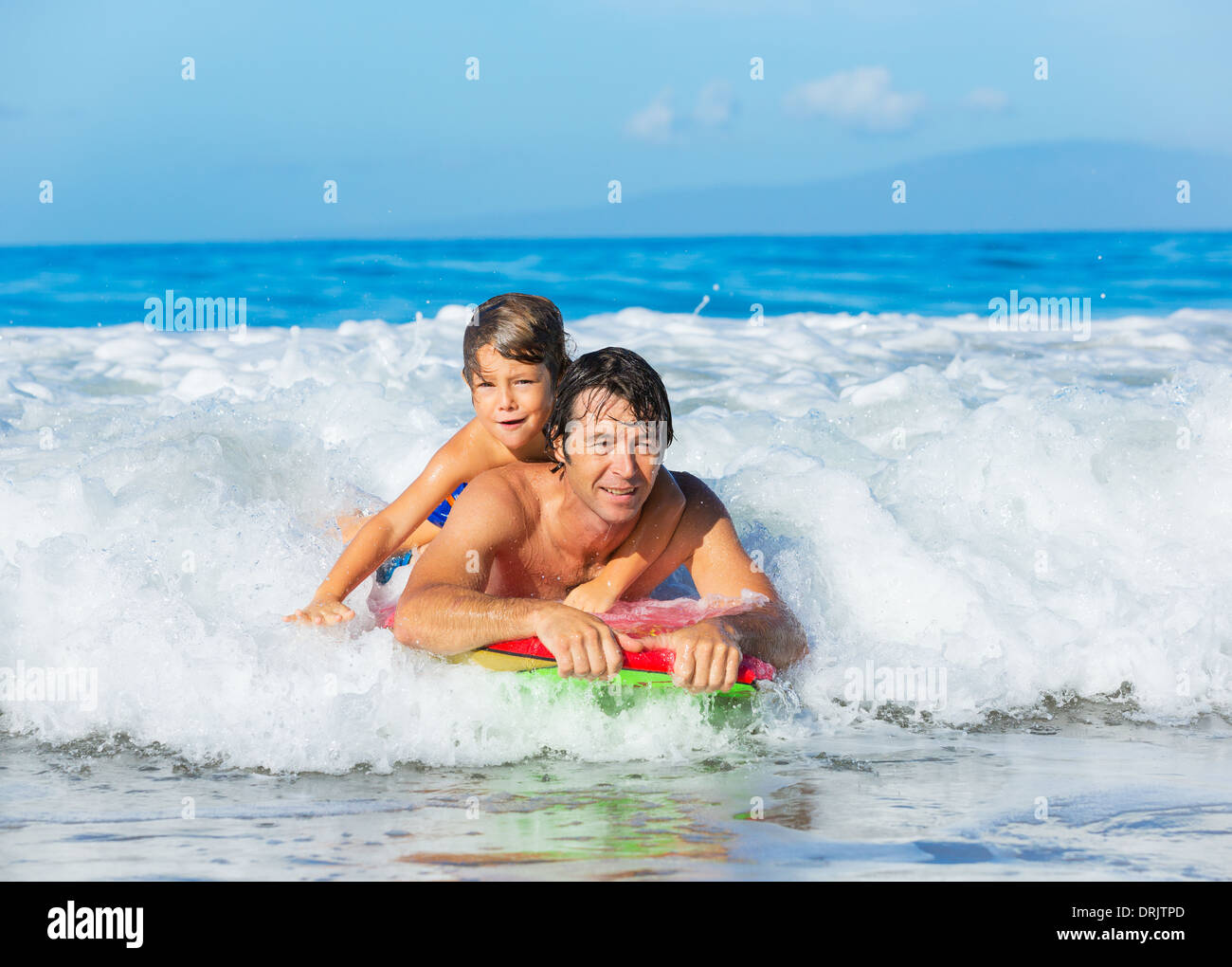 Vater und Sohn Surfen Tandem zusammen fangen Ocean Wave, sorglos glücklich Spaß Lächeln Lebensstil Stockfoto