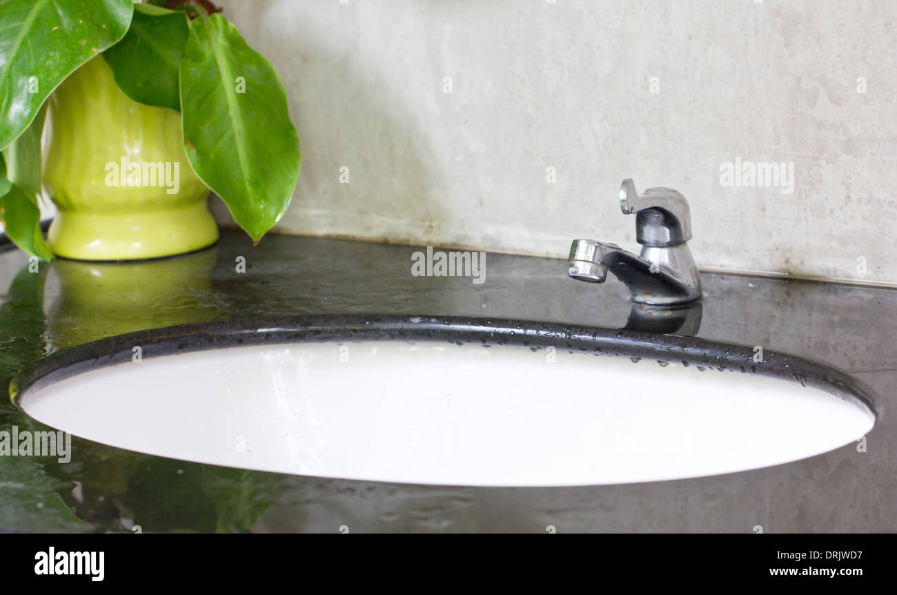 Weiße Keramik Waschbecken und Wasserhahn Chrom. Stockfoto