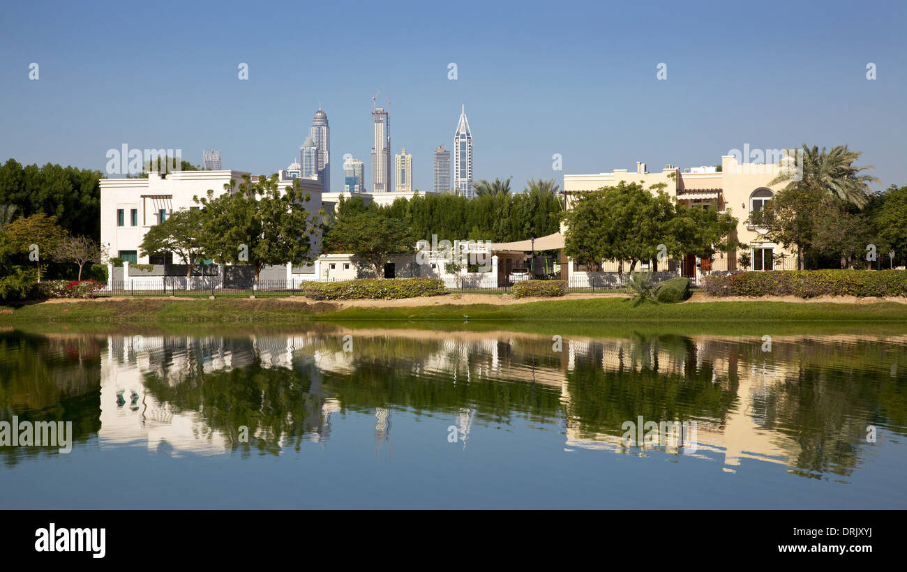 Luxuriöse Villen in Dubai, mit modernen Hochhäusern im Hintergrund. Stockfoto
