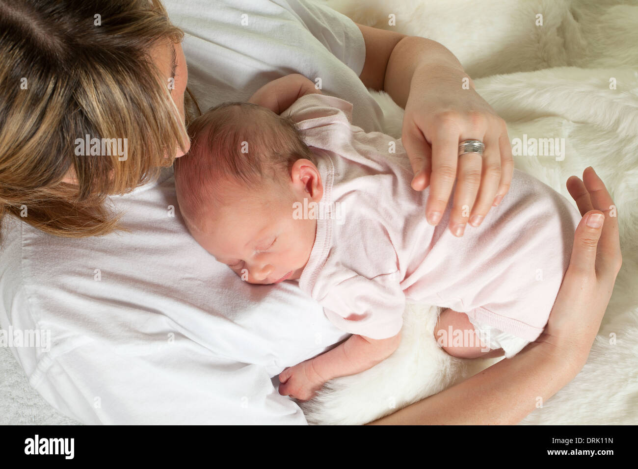Junge Liebende Mutter, die gerade ihr schlafendes Babys 18 Tage alt Stockfoto