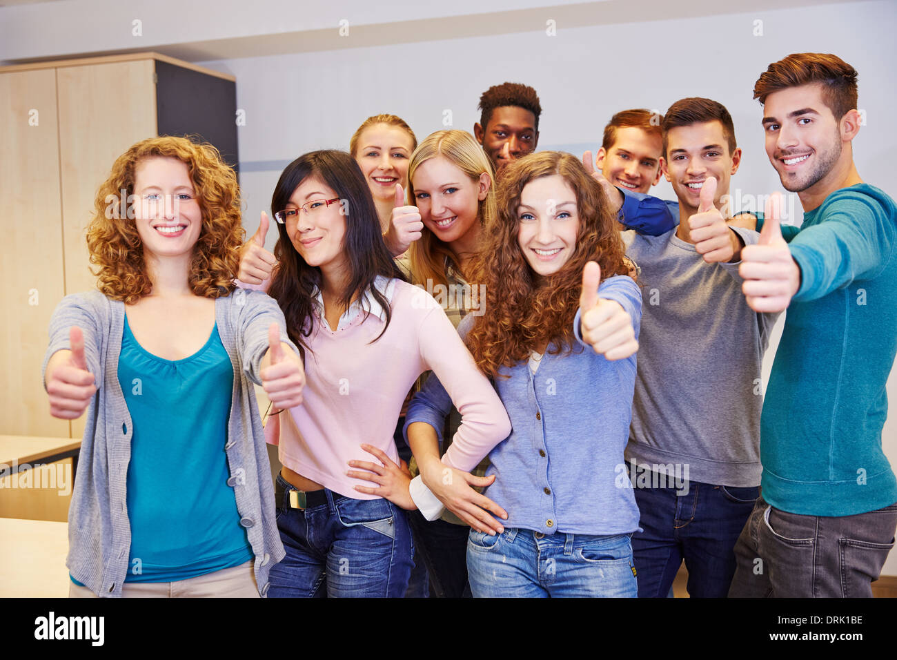 Gruppe Jugendlicher in einer Schulklasse die Daumen hochhalten Stockfoto