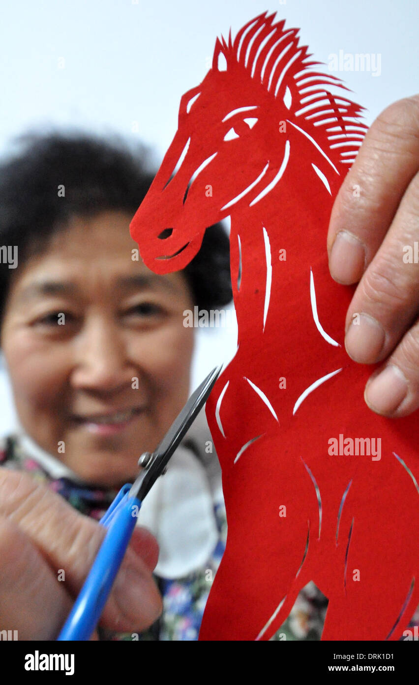 (140128)--HANDAN, 28. Januar 2014 (Xinhua)--Handicraftswoman Cai Chun'e schneidet ein Pferd aus einem Blatt Papier, um kommende chinesischen lunar New Year, Jahr des Pferdes, in Handan Stadt Nordchinas Provinz Hebei, 23. Dezember 2013 begrüßen. (Xinhua/Hao Qunying) (Cjq) Stockfoto