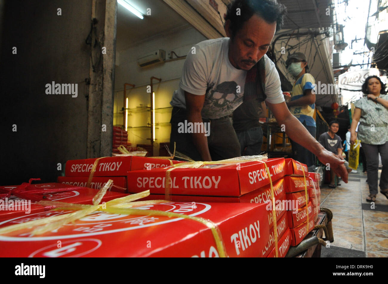 Manila, Philippinen. 28. Januar 2014. Eine Lieferung Mann ordnet Boxen '' Nian Gao'' oder Neujahr Kuchen, lokal bekannt als '' Tikoy'' für die Lieferung in einer kleinen Gasse im Bezirk Binondo, Manila am 28. Januar 2014. George Calvelo/NurPhoto/ZUMAPRESS.com/Alamy © Live-Nachrichten Stockfoto