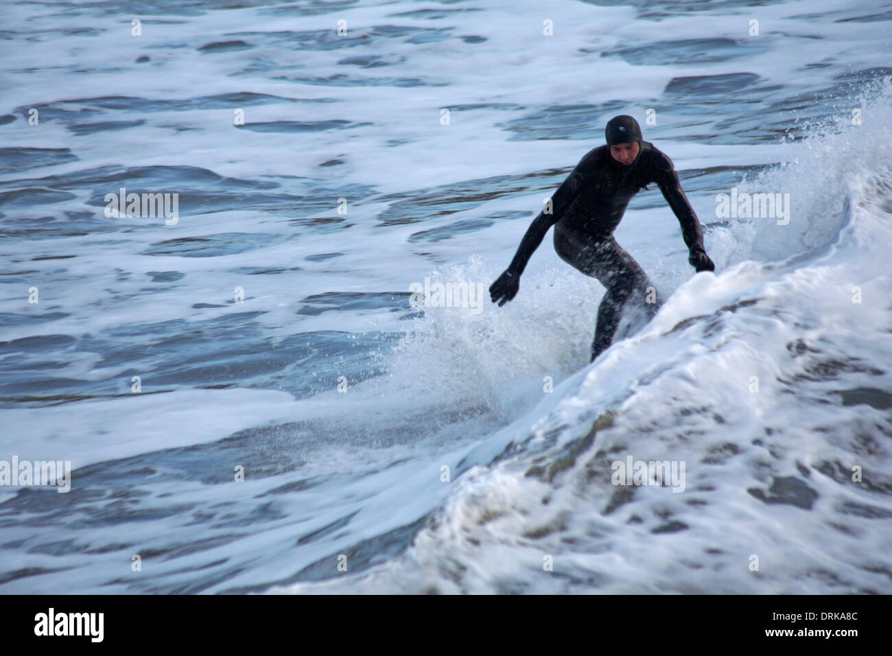 Bournemouth, Dorset, England Großbritannien Dienstag, 28. Januar 2014. Surfer auf einer Welle surfen und genießen die Wellen am Strand von Bournemouth Stockfoto