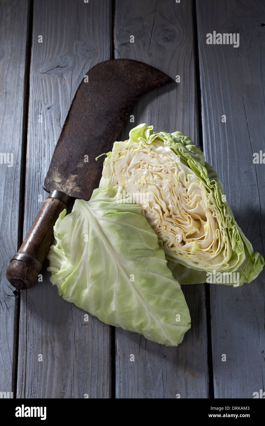 In Scheiben geschnitten spitz Kohl (Brassica Oleracea var. Capitata for Alba Subv. Conica) und antiken Wiegemesser auf grauem Holztisch Stockfoto
