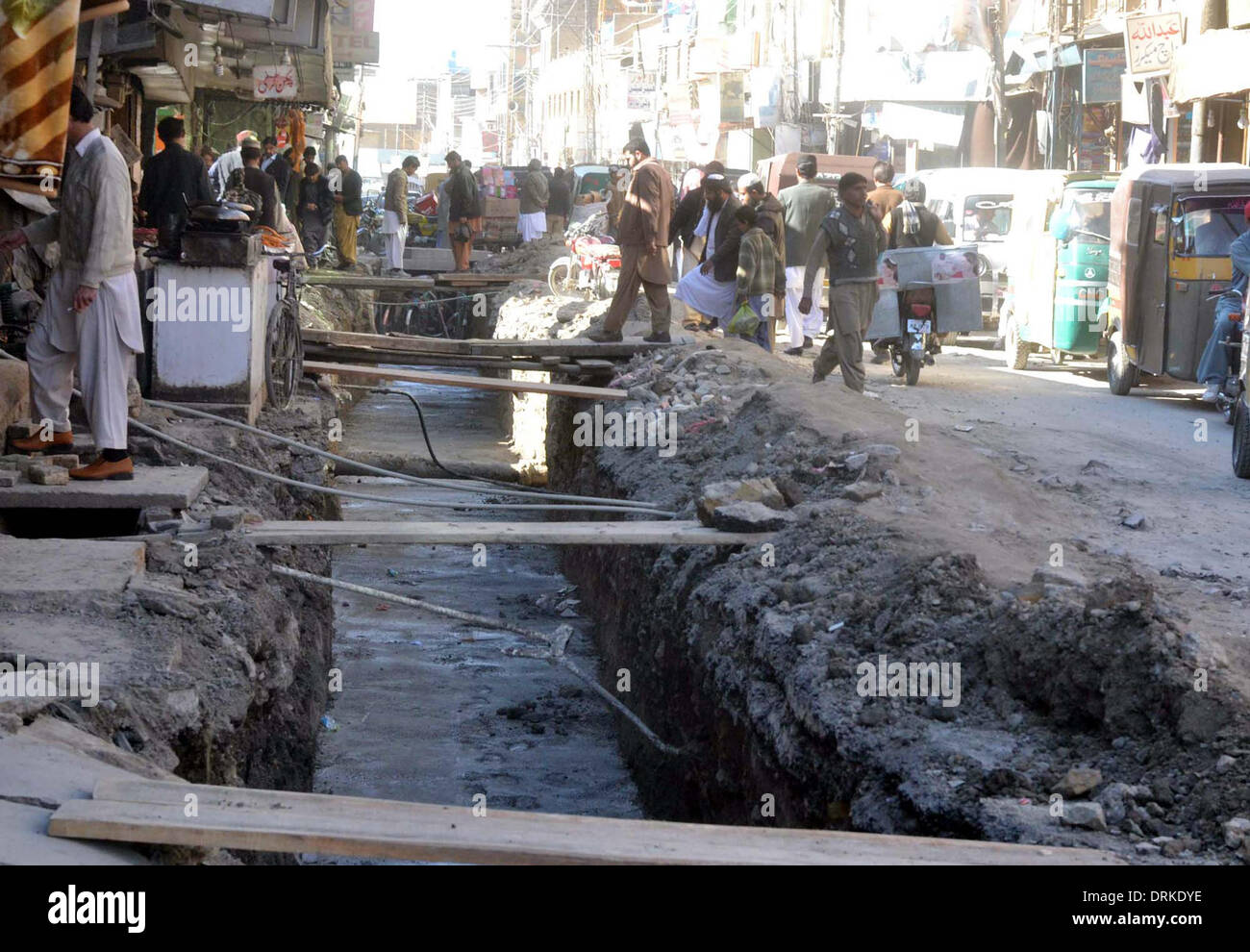 Pendler durchlaufen gegraben-Up Teil der Prince Road, wie langsame Tempo der Bauarbeiten Probleme für die Bewohner schafft und sie betroffene Abteilung Gesamtwerk so bald wie möglich in Quetta auf Dienstag, 28. Januar 2014 fordern. Stockfoto