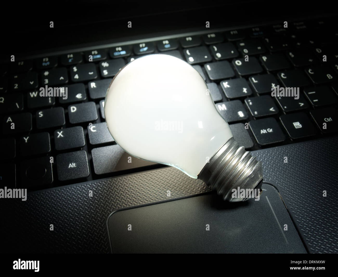 Glühbirne, der als Symbol für neue Ideen im Bereich Datenverarbeitung und Elektronik auf Ihrer Computertastatur beleuchtet wird. Stockfoto