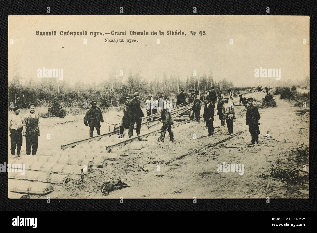 Arbeiter legen die Schienen der Transsibirischen Eisenbahn im Ural, dem Russischen Reich. 1906. Schwarz-Weiß-Vintage-Fotografie eines unbekannten Fotografen aus dem Anfang des 20. Jahrhunderts in der russischen Vintage-Postkarte herausgegeben von D.P. Jefimow, 1906. Text auf Russisch: Große Sibirische Eisenbahn. Gleisverlegung. Mit freundlicher Genehmigung der Azoor Postcard Collection. Stockfoto