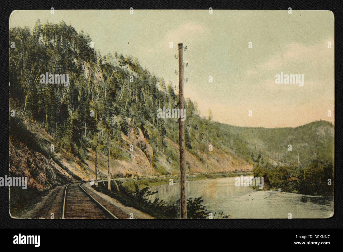Transsibirische Eisenbahn entlang des Flusses SIM im Ural, Russisches Reich. Schwarz-Weiß-Vintage-Fotografie eines unbekannten Fotografen aus dem Anfang des 20. Jahrhunderts in der russischen Vintage-Postkarte herausgegeben von D.P. Jefimow, 1906. Text auf Russisch: Eisenbahn entlang des Flusses SIM zwischen den Stationen Asha und Minyar. Minyar und Asha sind Städte in Tscheljabinsk Region, Russland. Mit freundlicher Genehmigung der Azoor Postcard Collection. Stockfoto