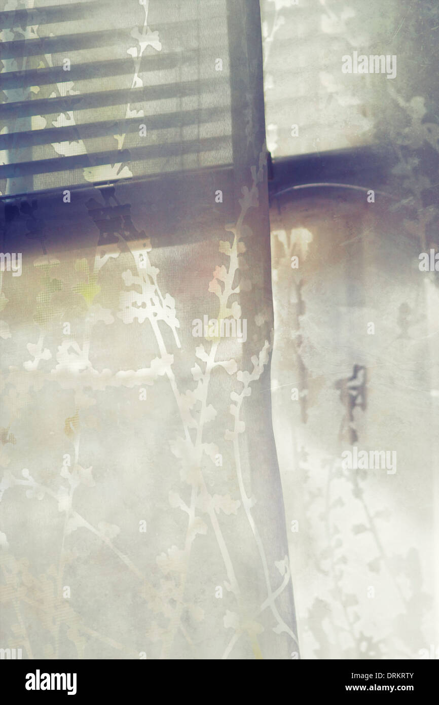 Ein schiere Vorhang mit einem Blatt-Design weht in einer Brise. Stockfoto