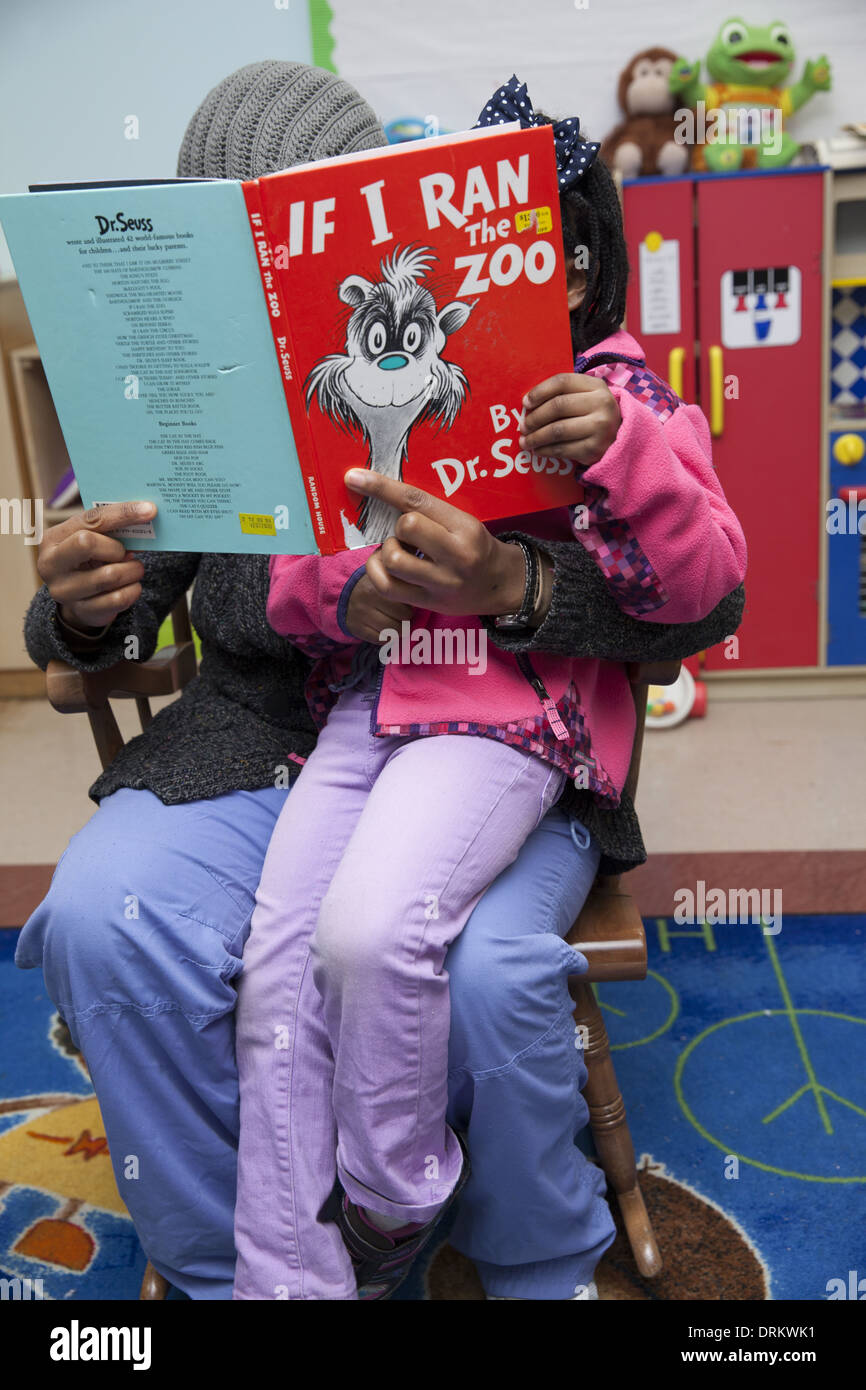 Mutter und Tochter Dr. Seuss lesen Sie gemeinsam in einem Gemeindezentrum in lower Manhattan. Stockfoto