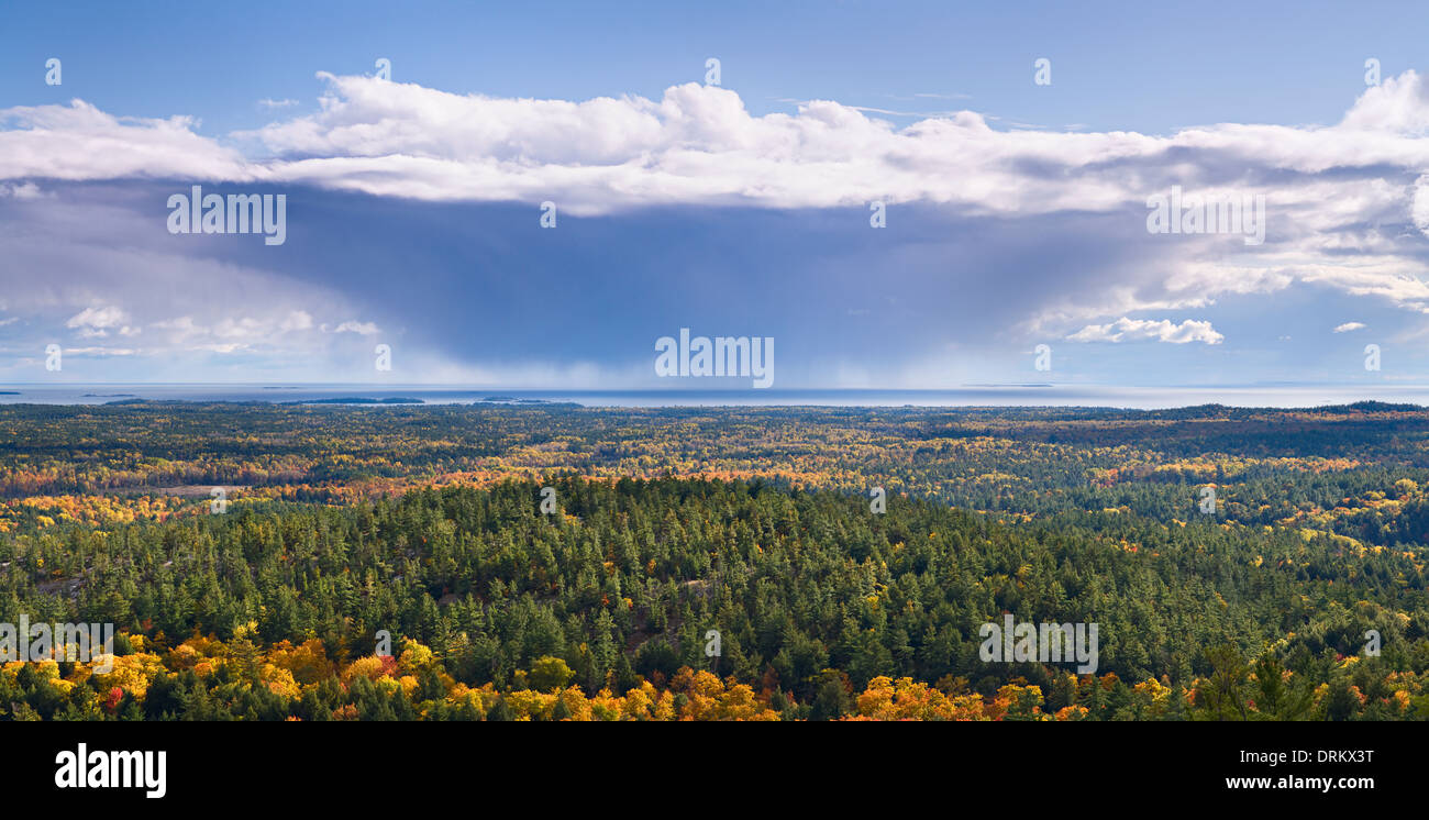 Eine Gewitterwolke Rückzug über einen weitläufigen Blick auf die Herbstfarben in Killarney Provincial Park, Ontario, Kanada. Stockfoto