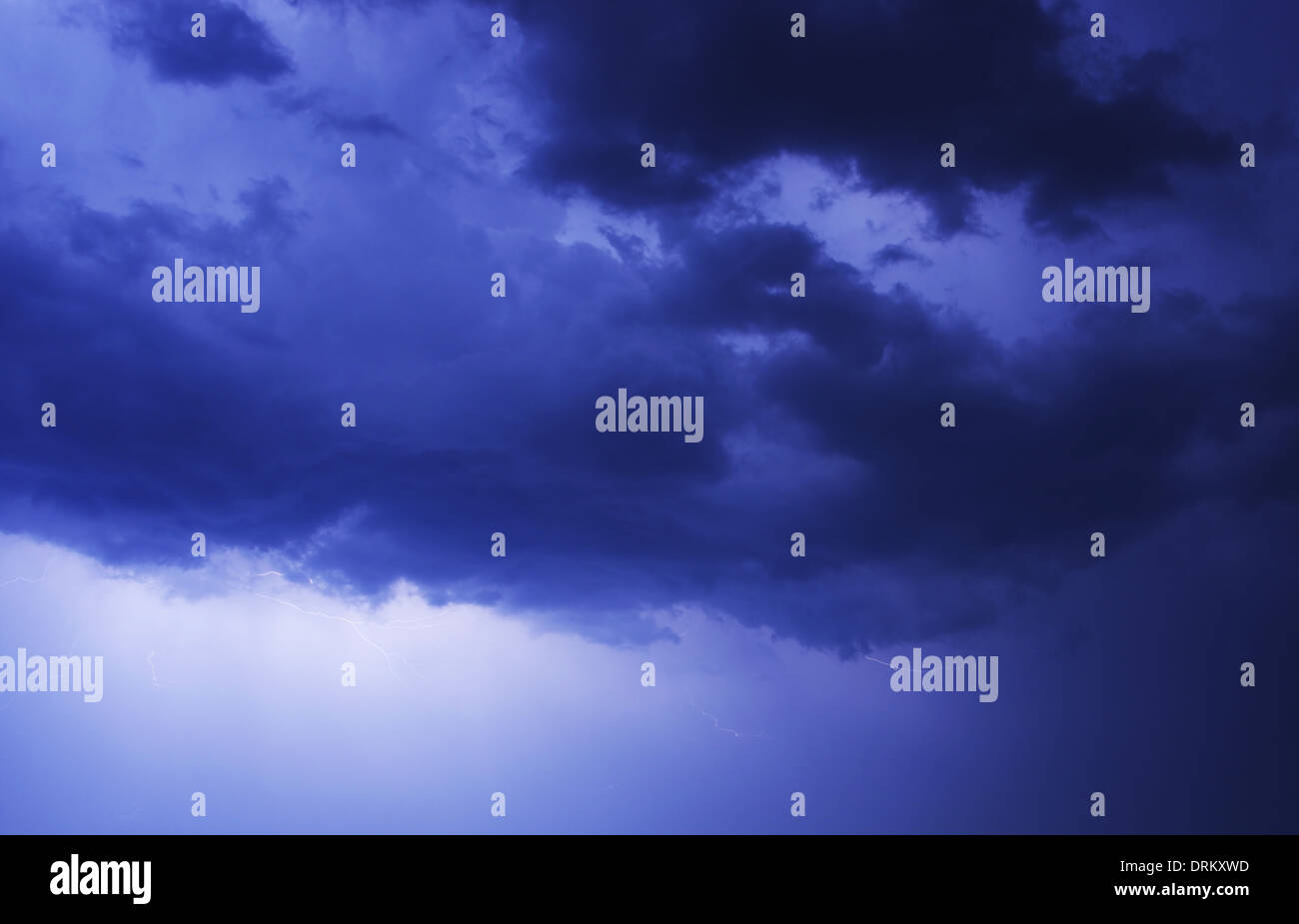 Stormy Blue Night Sky Fotohintergrund. Kleine Blitze zwischen den Wolken. Wetter-Foto-Sammlung. Stockfoto