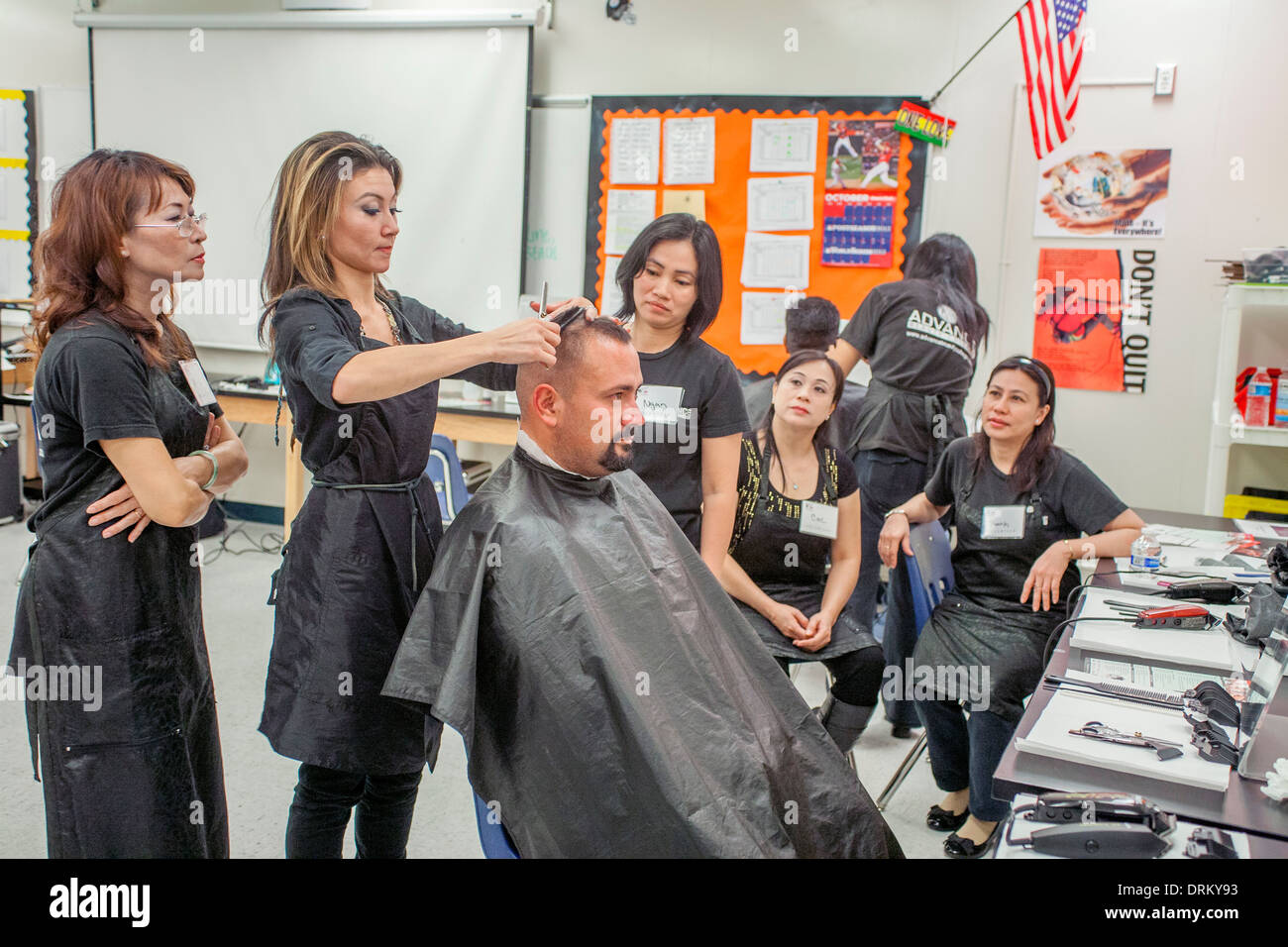 Als asiatisch-amerikanische sehen Friseure, ein Mann bekommt einen neuen Haarschnitt von Arbeiten Schränke, eine Organisation, die hilft, die Arbeitslose Kleid und der Bräutigam für erfolgreiches Geschäft Vorstellungsgespräche in Südkalifornien. Der Haarschnitt ist Teil einer "Beschäftigung Erfolg Workshop. Stockfoto