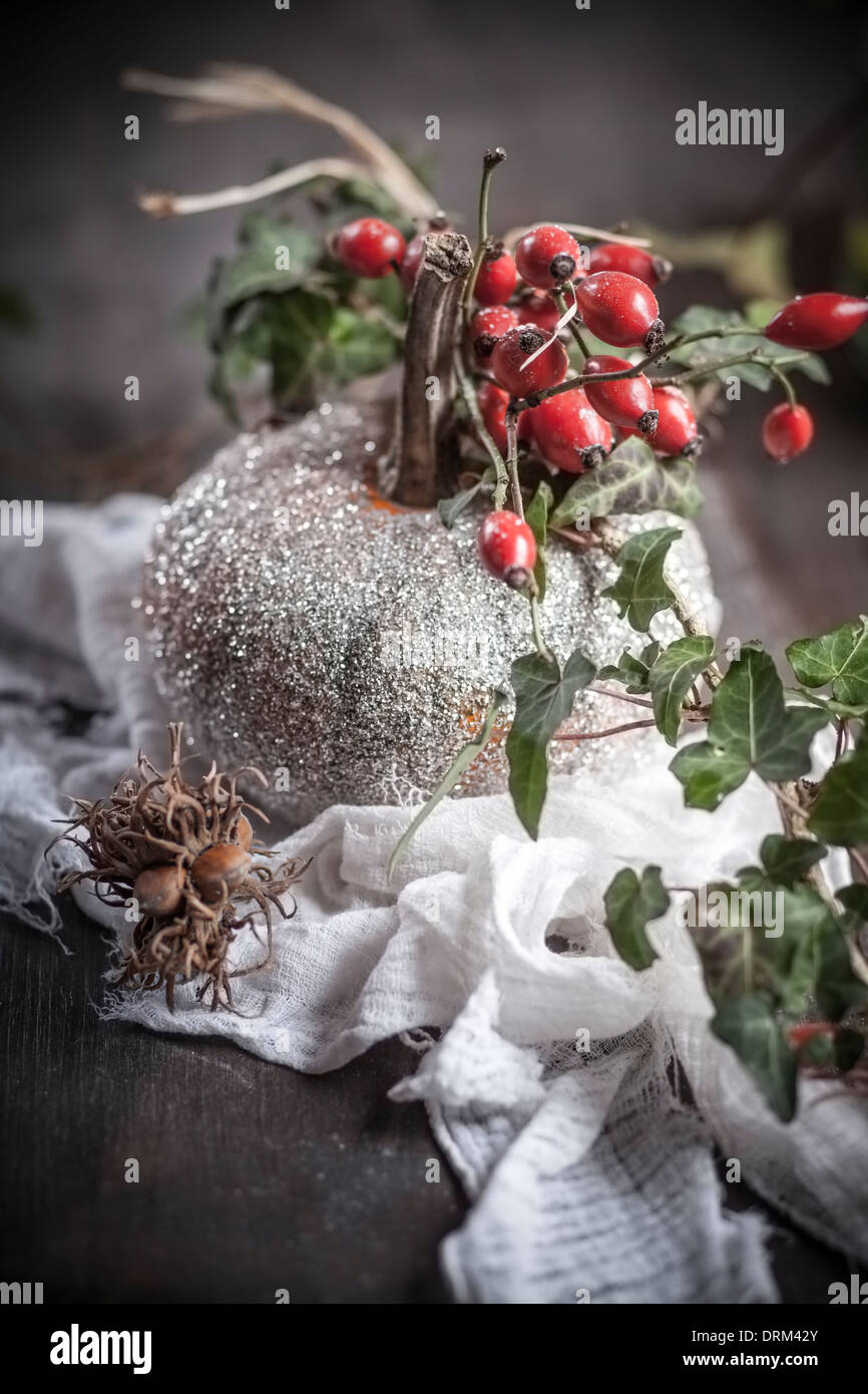 Halloween-Dekoration, glitzernde Krbis mit Efeu-Ranke und Hagebutten auf  Holztisch Stockfotografie - Alamy