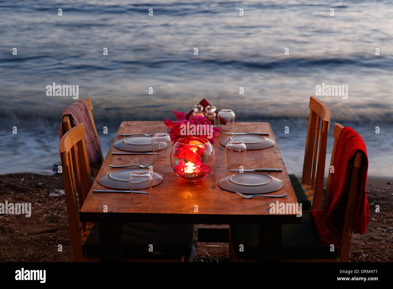 Türkei, Bodrum, Guemuesluek, Laid Tisch am Strand in der Abenddämmerung Stockfoto