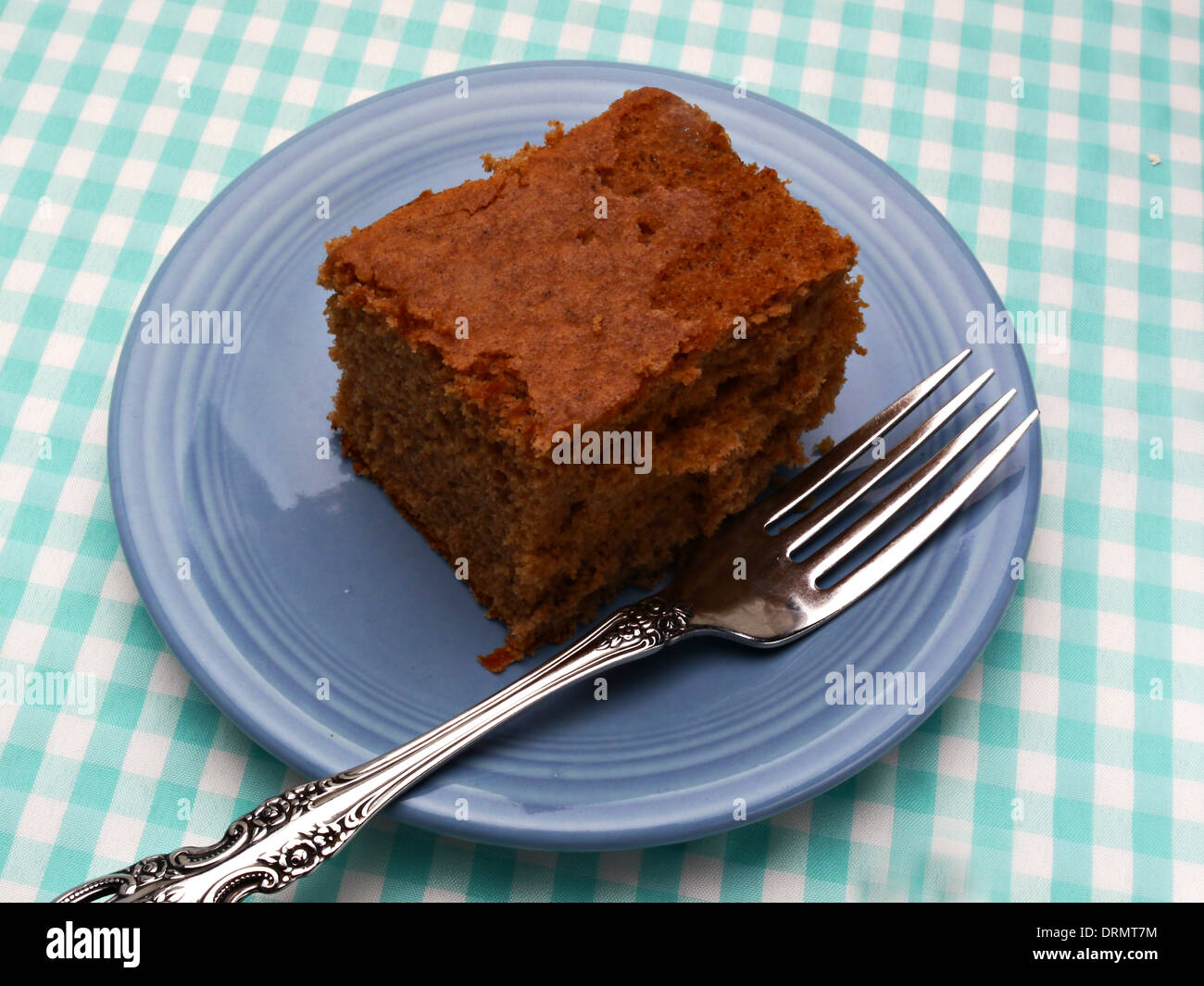 Ein Stück hausgemachte Gewürzkuchen ist auf eine blaue Untertasse. Stockfoto