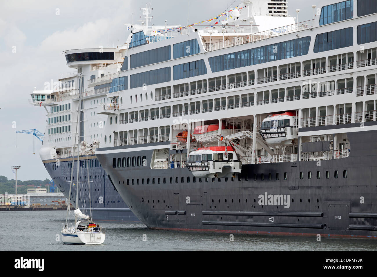 Segelboot und Kreuzfahrt-Schiffe im Hafen von Kiel in Deutschland Stockfoto